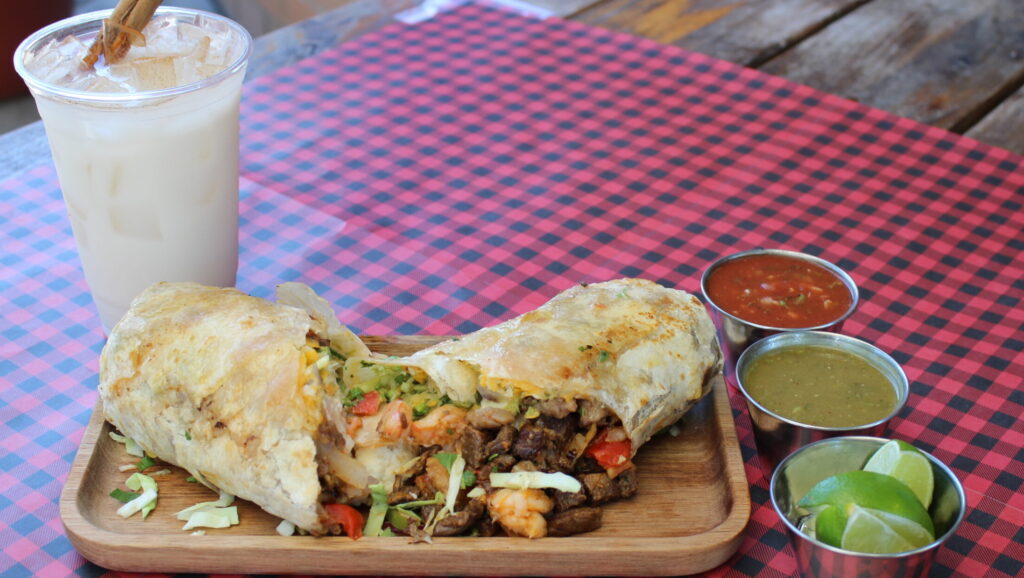 Steak and shrimp burrito served with salsa at Los Tacos Locos